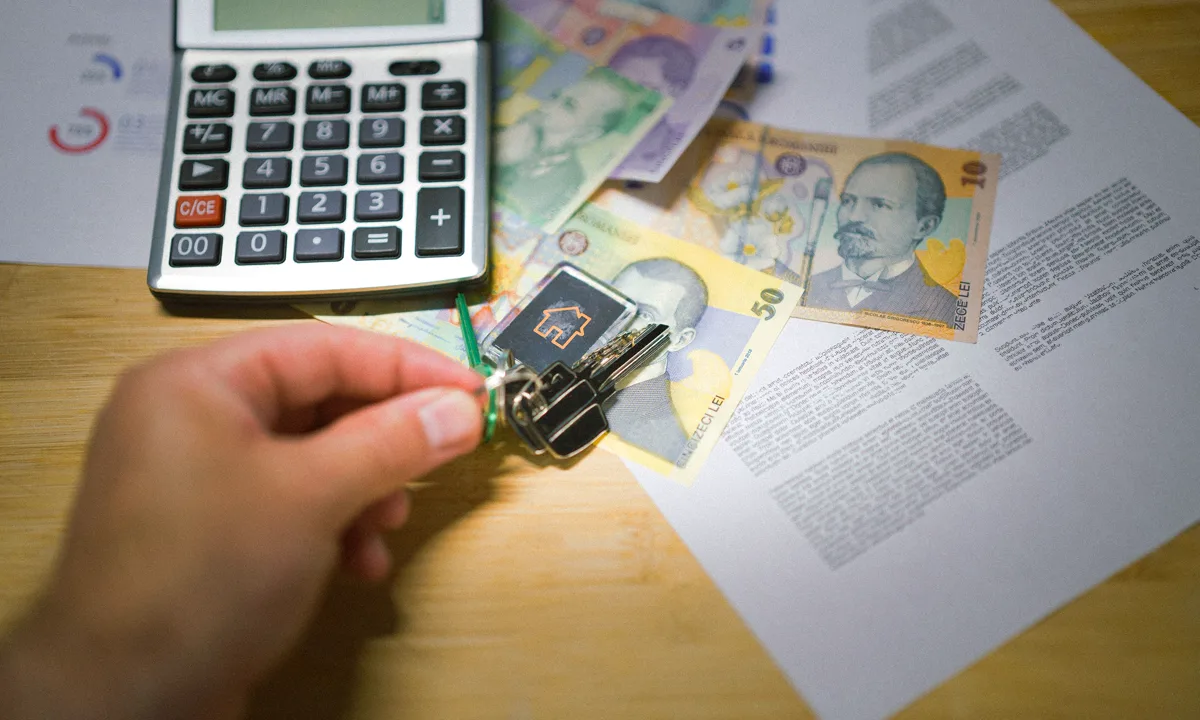 House keys, calculator, currency, and property documents arranged for a tax calculation