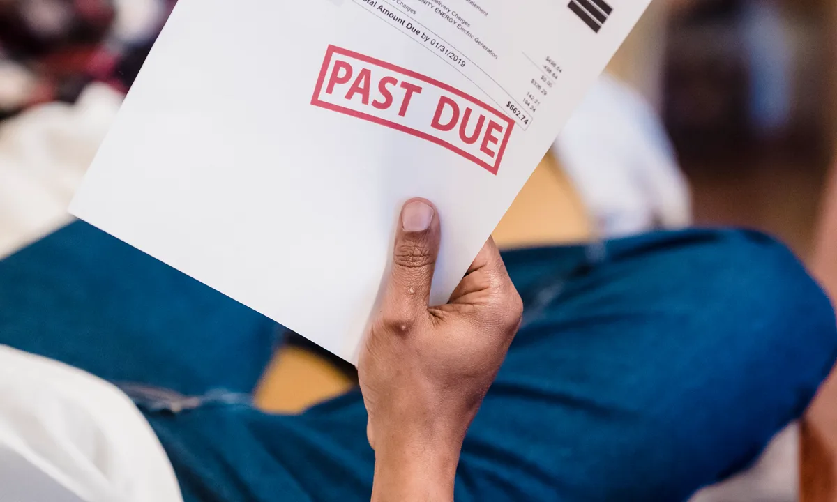 Homeowner reviewing a past-due billing statement at a table