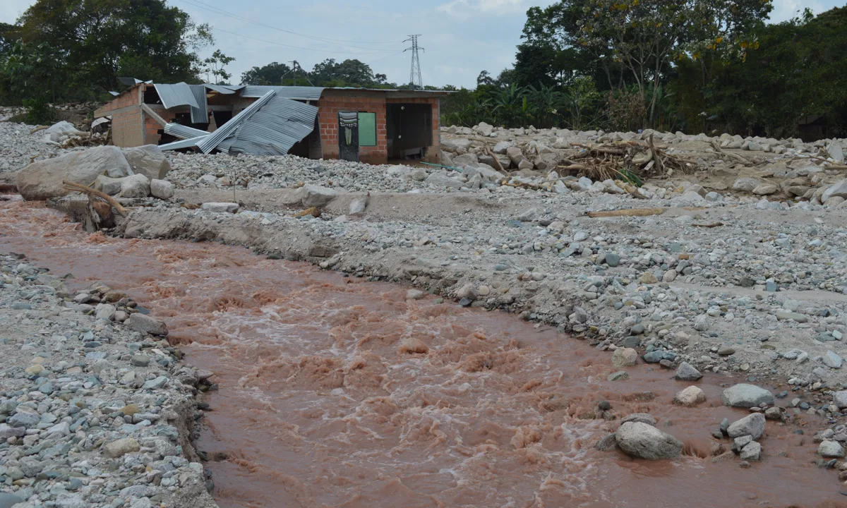 Flood-damaged house beside muddy water after a severe storm