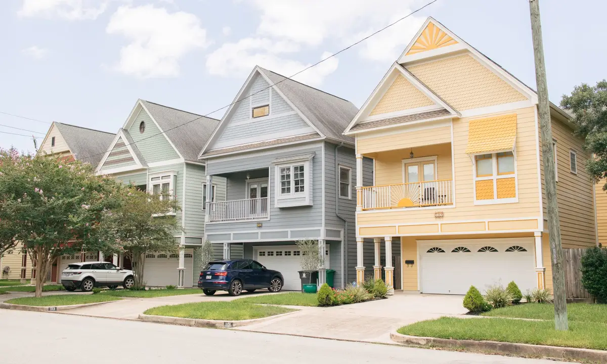 Row of colorful two-story homes with driveways on a residential street