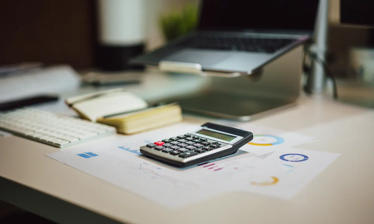 Calculator resting on financial documents at an office desk