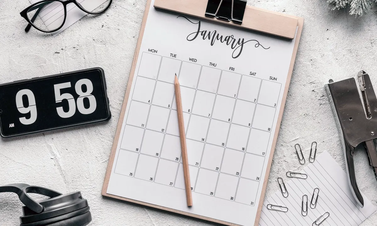 Desk calendar and office tools arranged for planning deadlines