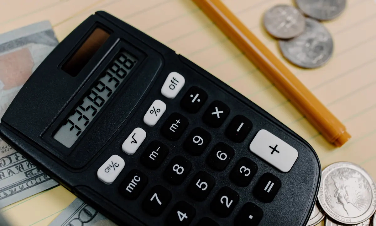 Calculator, cash, and coins arranged on a tax-planning notepad