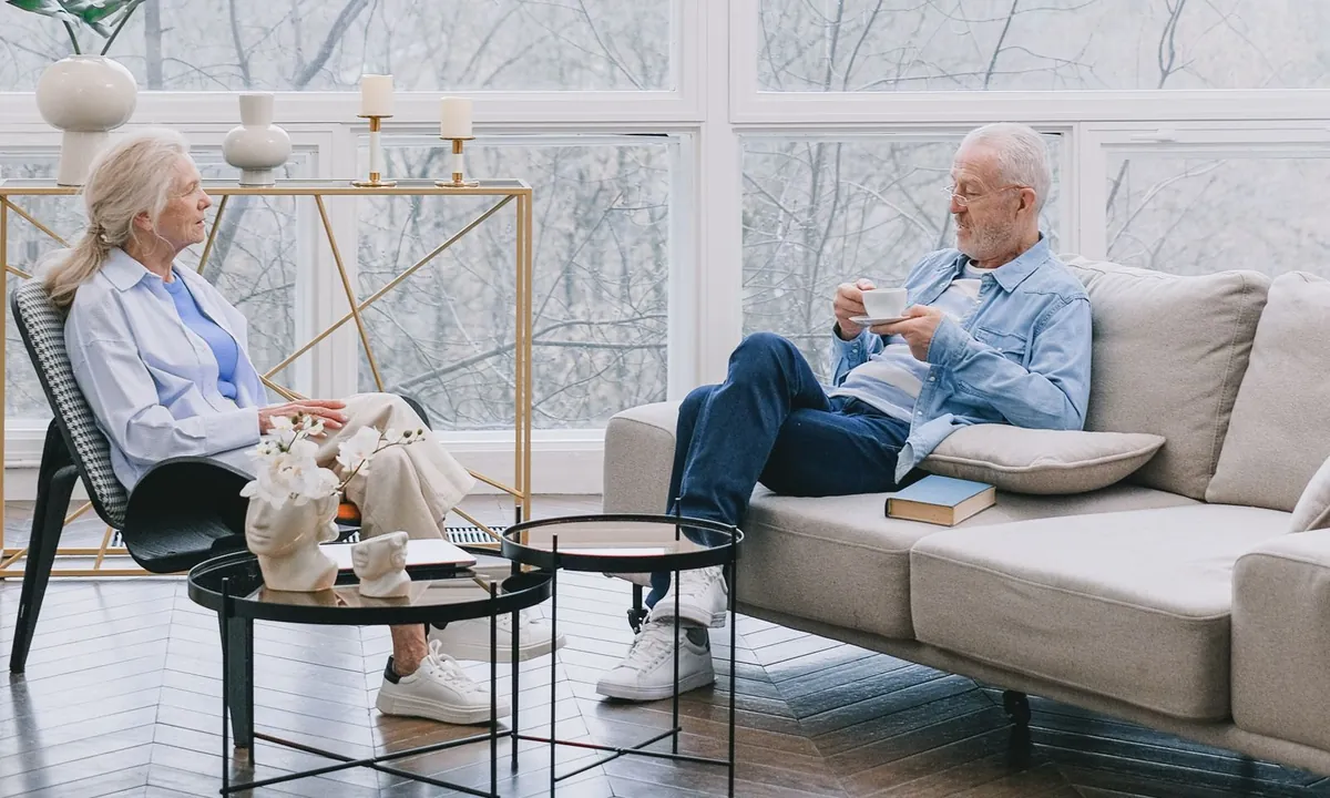 Older couple sitting together with coffee in a bright living room