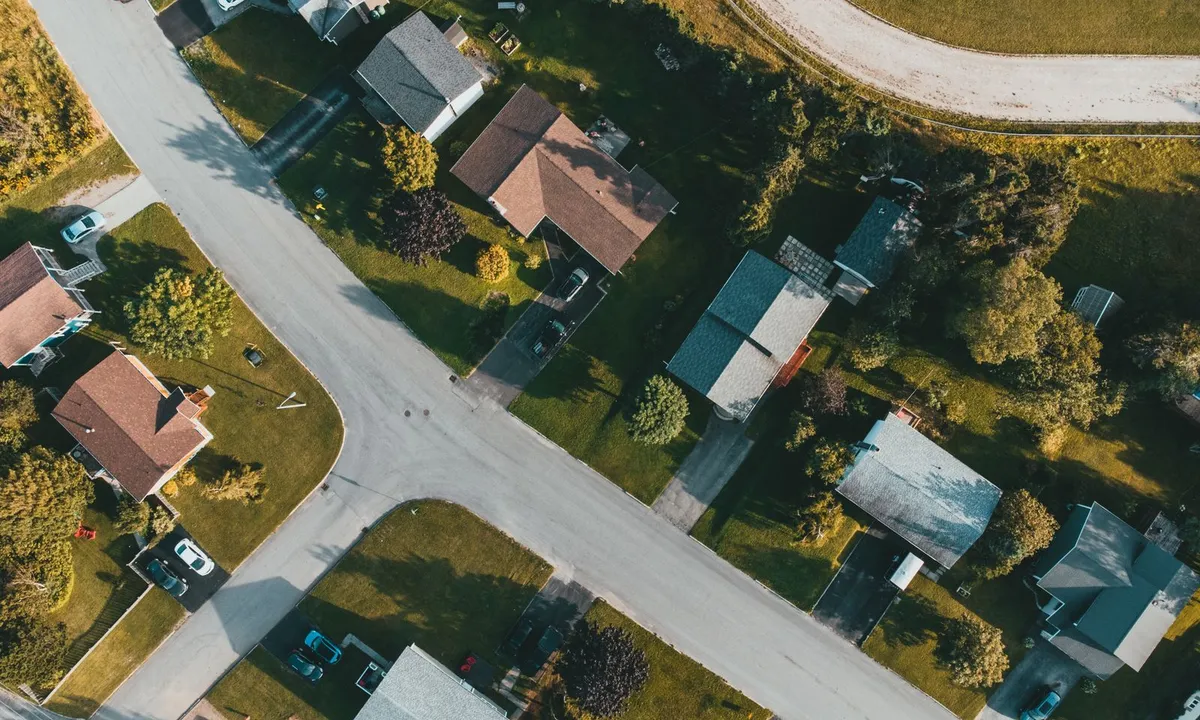 Aerial view looking straight down on a suburban street with houses, lawns and trees