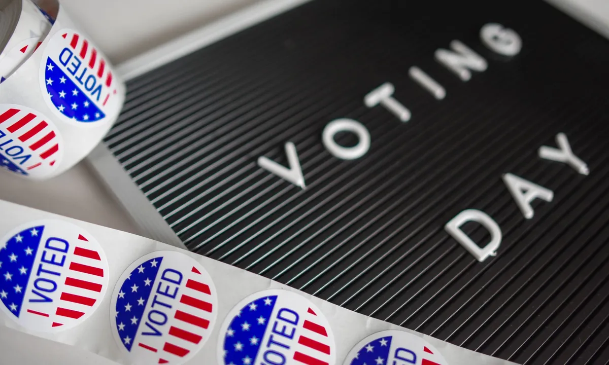 Rolls of “I Voted” stickers beside a letter board that reads “Voting Day”